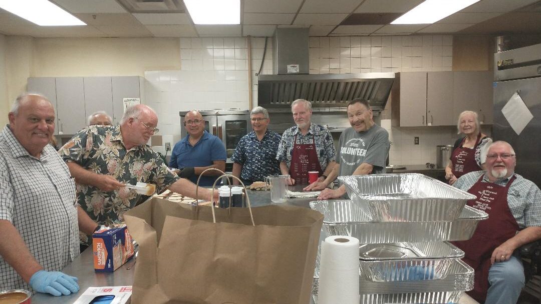 Members of the Men's Cub preparing food to be served at the Arlington Life Shelter