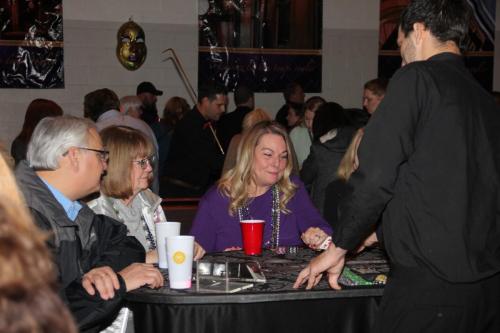 Guests playing table games at the Mardi Gras Casino party. 