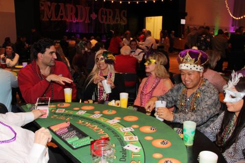 Guests playing table games at the Mardi Gras Casino party. 
